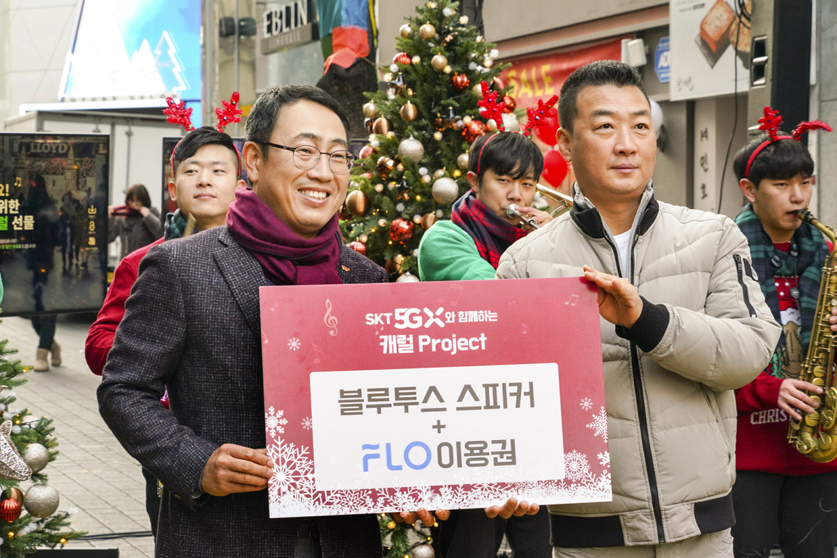 ▲ SK텔레콤 유영상 MNO사업부장(사진 왼쪽)이 명동복지회 임원 이강수 씨에게 캐럴 스트리밍용 블루투스 스피커를 전달하고 있다. (SKT 제공)