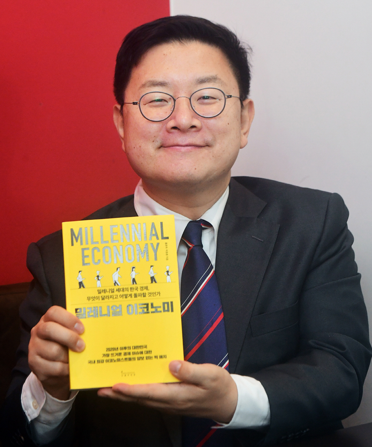 ▲홍춘욱 EAR리서치 대표가 18일 서울 마포구 합정동의 한 카페에서 이투데이와의 인터뷰에 앞서 자신의 저서 ‘밀레니얼 이코노미’를 들어 보이며 포즈를 취하고 있다. 고이란 기자 photoeran@