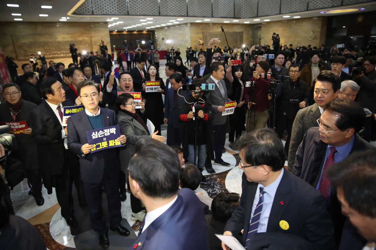 ▲국회 본회의 개의가 예정된 23일 오후 더불어민주당 의원들이 본회의장으로 들어서자 본회의장 앞에서 자유한국당 의원들이 구호를 외치고 있다.   (연합뉴스)