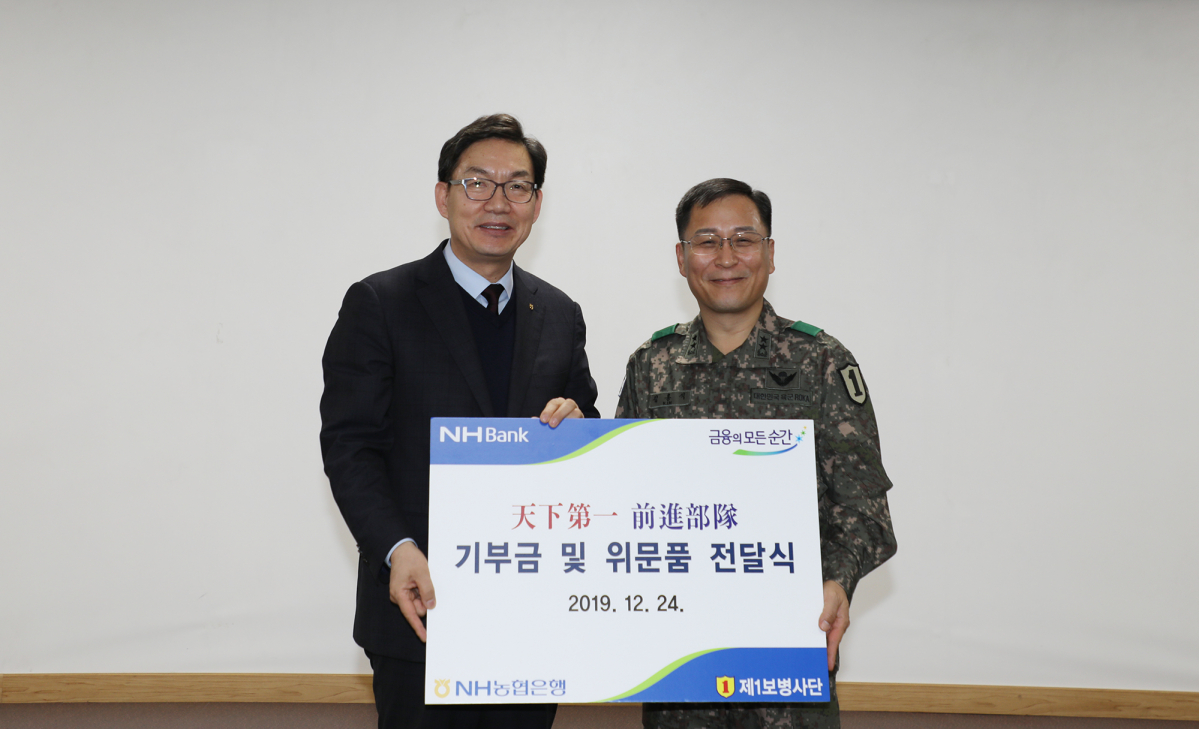 ▲이대훈 은행장(왼쪽)이 지난 24일 지난 24일 경기도 파주시에 위치한 육군 제1보병사단을 방문해 국군장병들을 격려하고 위문금과 위문품을 전달하고 김홍석 사단장과 기념사진을 찍고 있다. (사진제공=NH농협은행)