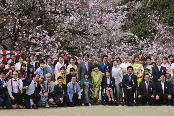 ▲아베 신조(가운데 분홍색 넥타이) 일본 총리가 4월 15일(현지시간) 도쿄에서 정부 주관의 ‘벚꽃 보는 모임’ 행사에 참석해 초청을 받은 예술가와 운동선수, 기타 손님들과 단체 기념사진을 찍고 있다. 도쿄/AP뉴시스 
