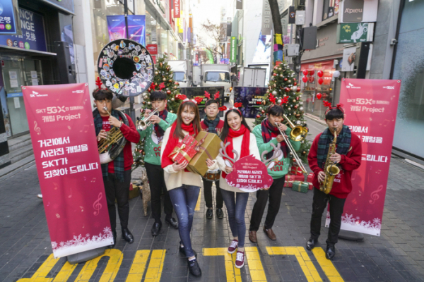 ▲19일 오전 서울 명동 한가운데에서 크리스마스 브라스밴드가 캐럴 공연을 하며 ‘캐럴이 돌아왔다’ 프로젝트를 알리고 있다. (SKT 제공)