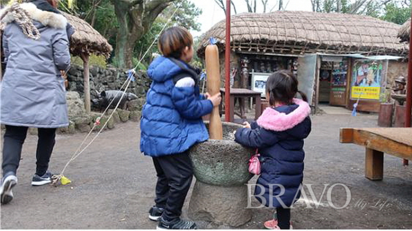 ▲제주민속촌을 방문한 아이들이 방아 찍기 체험을 하고 있다(홍지영 동년기자)