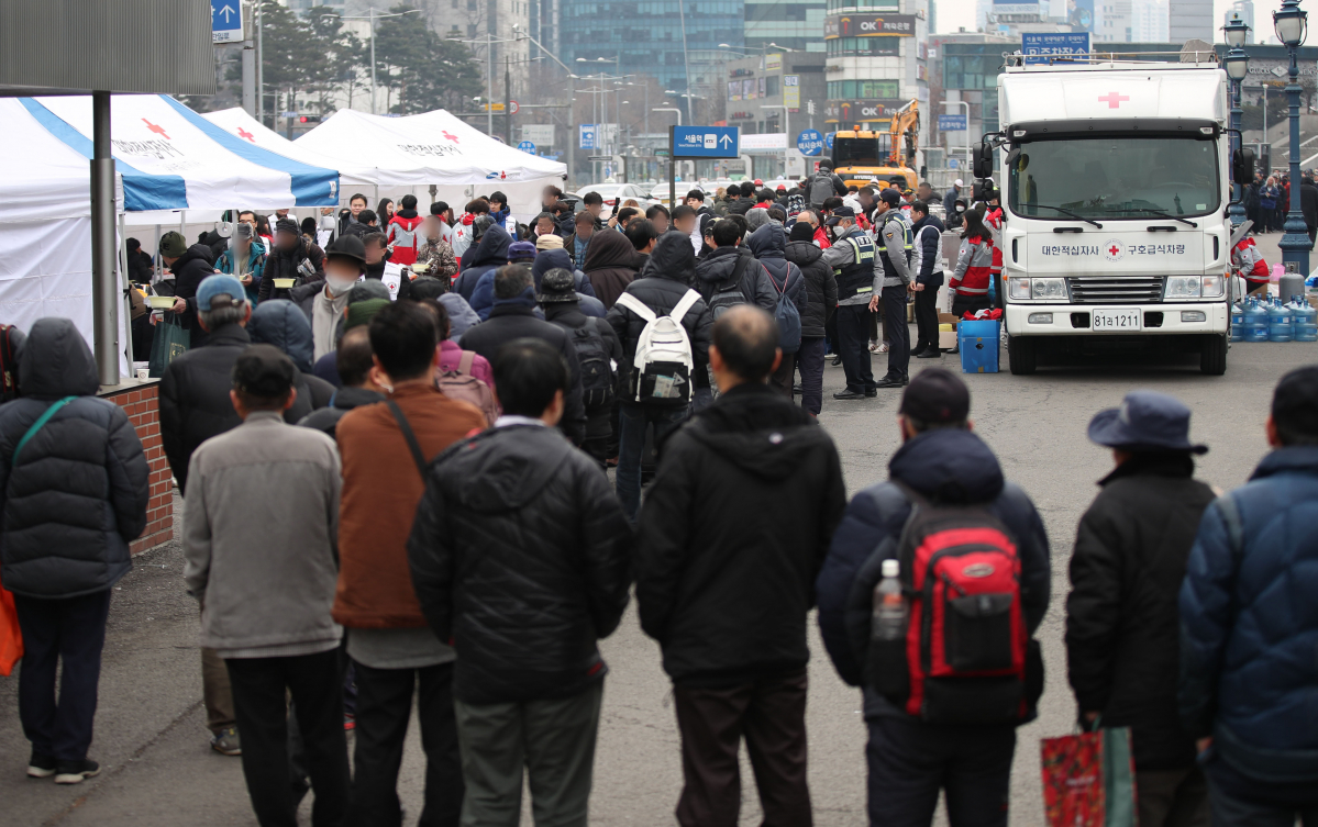 ▲대한적십자사 관계자들이 2일 서울역 광장에서 대한적십자사 2020년 경자년 시무식 떡국 나눔 봉사활동에서 노숙인 및 인근 독거노인들에게 떡국을 배식하고 있다.  (뉴시스)