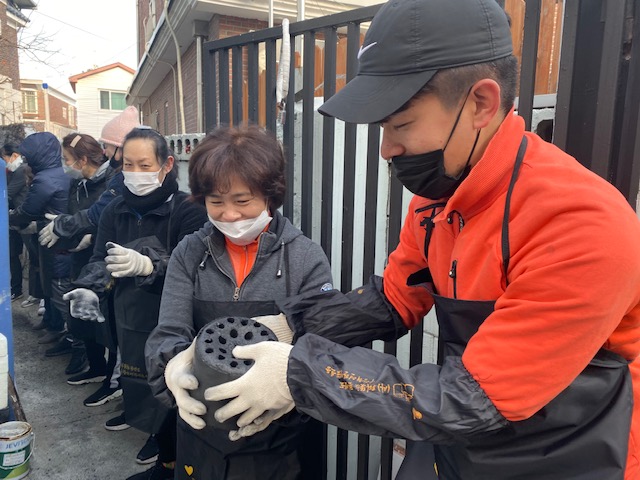 ▲티시스 임직원이 지난해 12월 16일 수원시 팔달구에서 저소득층 독거노인에게 연탄을 전달하고 있다. (사진제공=태광그룹)