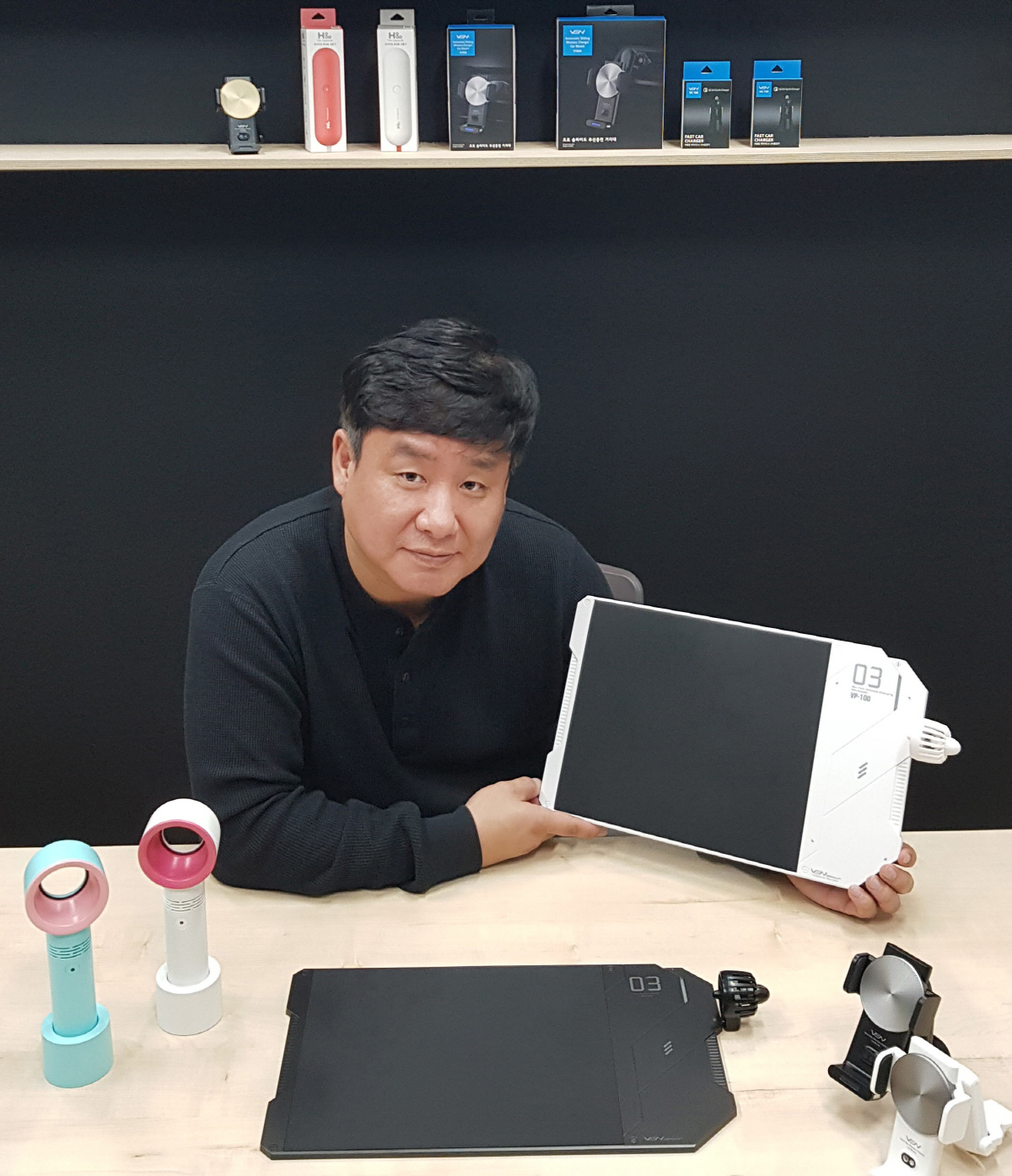 ▲김정식 벤그룹 대표가 최근 론칭한 서큘레이터가 결합된 ‘고속무선충전 마우스패드’를 들어보이고 있다. 김 대표는 국내 최초로 젤타입 흡착 패드를 적용한 휴대전화 거치대 ‘대쉬크랩’을 개발해 업계의 이목을 끌었다. 사진제공 벤그룹