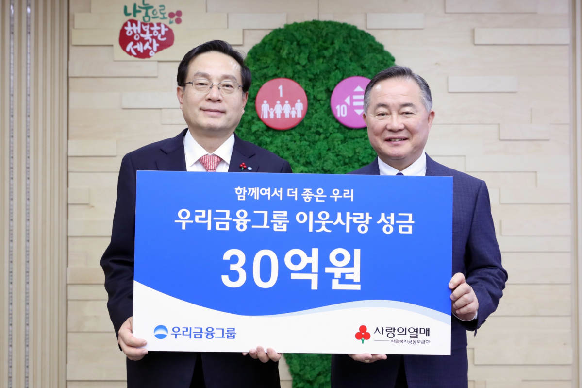 ▲손태승 우리금융 회장(왼쪽)이 예종석 사회복지공동모금회 회장에게 13일 서울 중구에 있는 사회복지공동모금회에서 성금을 전달하고 기념촬영을 하고 있다. (사진제공=우리금융)
