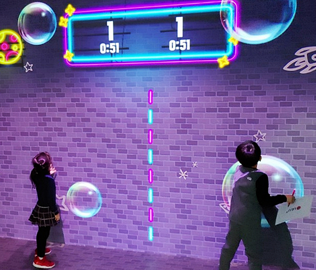 ▲롯데하이마트 잠실점 내 구축된 미디어 체험 놀이 공간 ‘U+아이들나라’에서 방문객이 손으로 터치하며 즐기는 ‘인터랙티브 게임’을 체험하고 있다.  (사진제공=LG유플러스)