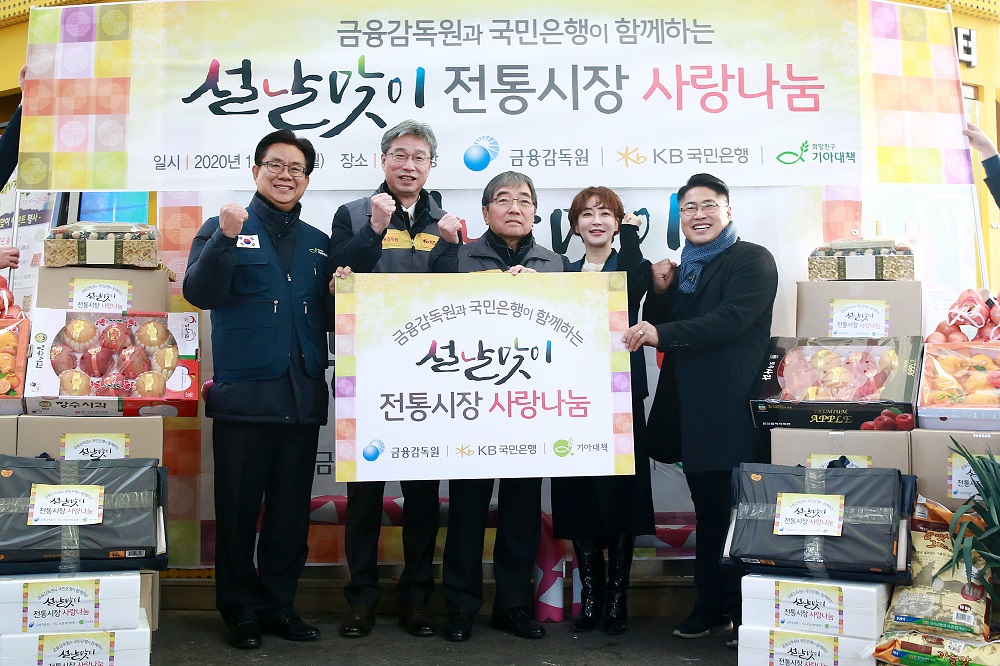 ▲윤석헌 금융감독원장(가운데)와 허인 KB국민은행장(왼쪽서 두번째)가 20일 서울 마포구 망원시장에서 나눔활동을 한 뒤 관계자들과 기념촬영을 하고 있다. (사진제공=금융감독원)