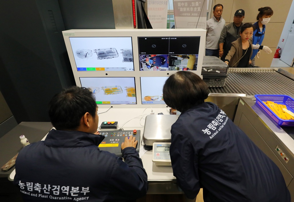 ▲인천국제공항 제2터미널 입국장에서 농림축산검역본부 직원들이 입국하는 승객들의 휴대품을 검역하고 있다. (뉴시스)