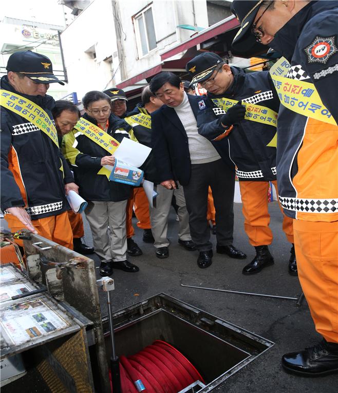 ▲신열우 서울소방재난본부장이 남대문시장 바닥에 설치된 시민자율소방함을 열어 상태를 점검하고 있다. (사진 = 서울시)