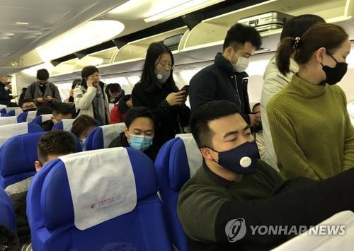 ▲ 21일 중국 상하이(上海)를 출발해 우한(武漢)으로 향하는 항공기에 탄 승객들이 신종 코로나바이러스 감염을 막고자 마스크를 쓰고 있다.  (연합뉴스)