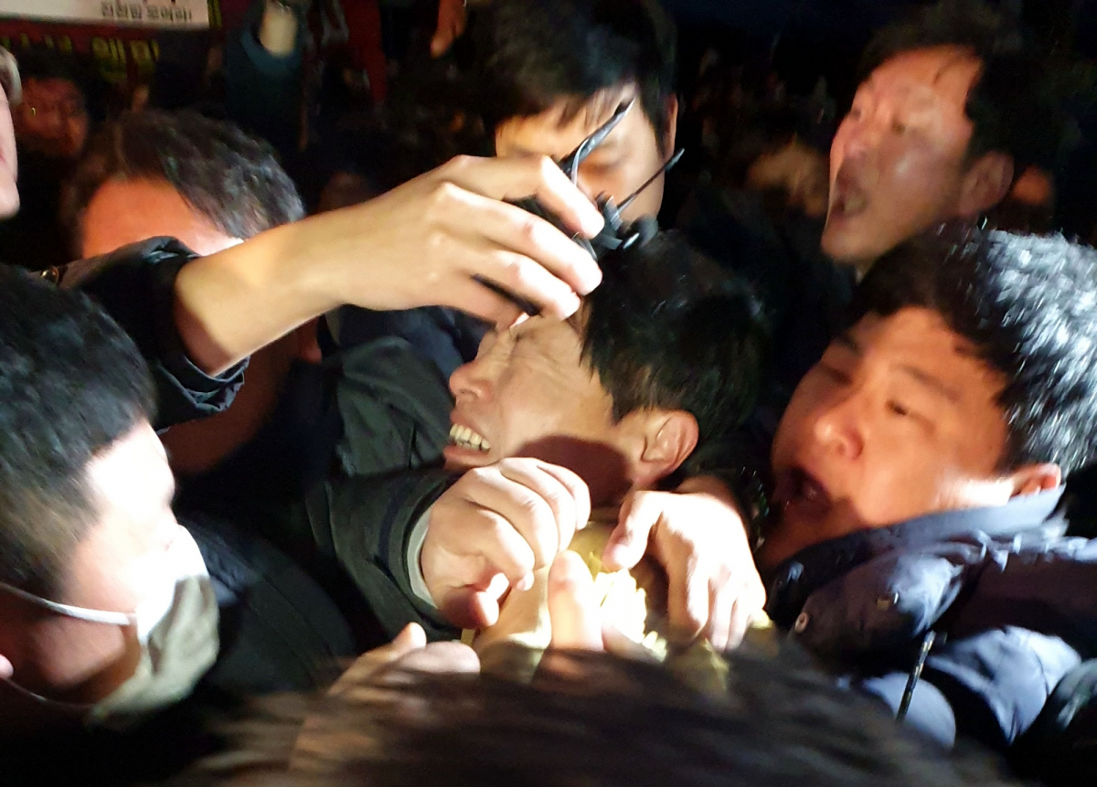 ▲29일 중국 우한 교민의 국내 격리수용 장소로 결정된 충북 진천군 덕산면 국가공무원인재개발원을 찾은 김강립 보건복지부 차관이 격앙된 진천군민의 거센 항의 속에 인파에 파묻혀 괴로워하고 있다.  (뉴시스)