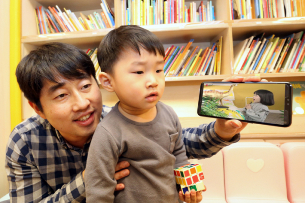 ▲LG유플러스는 어린이들이 선호하는 동화, 자연관찰, 과학 등의 콘텐츠를 3D AR로 생동감있게 즐길 수 있는 모바일 교육 애플리케이션 ‘U+아이들생생도서관’을 17일 출시한다고 14일 밝혔다. 자녀와 부모고객이 U+아이들생생도서관을 이용하고 있는 모습. (LG유플러스 제공)