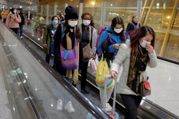 ▲25일 중국 베이징 공항에 도착한 여행객들이 마스크를 쓴 채 에스컬레이터를 타고 이동하고 있다. (연합뉴스)