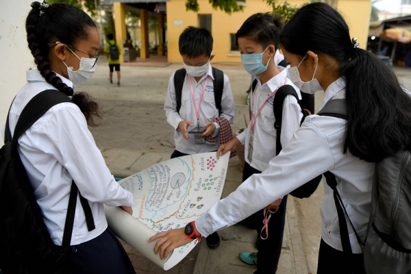 ▲신종 코로나바이러스 감염자가 나온 캄보디아 프놈펜에서 28일 어린이들이 마스크를 쓴 채 숙제를 논의하고 있다. 프놈펜/AFP연합뉴스
