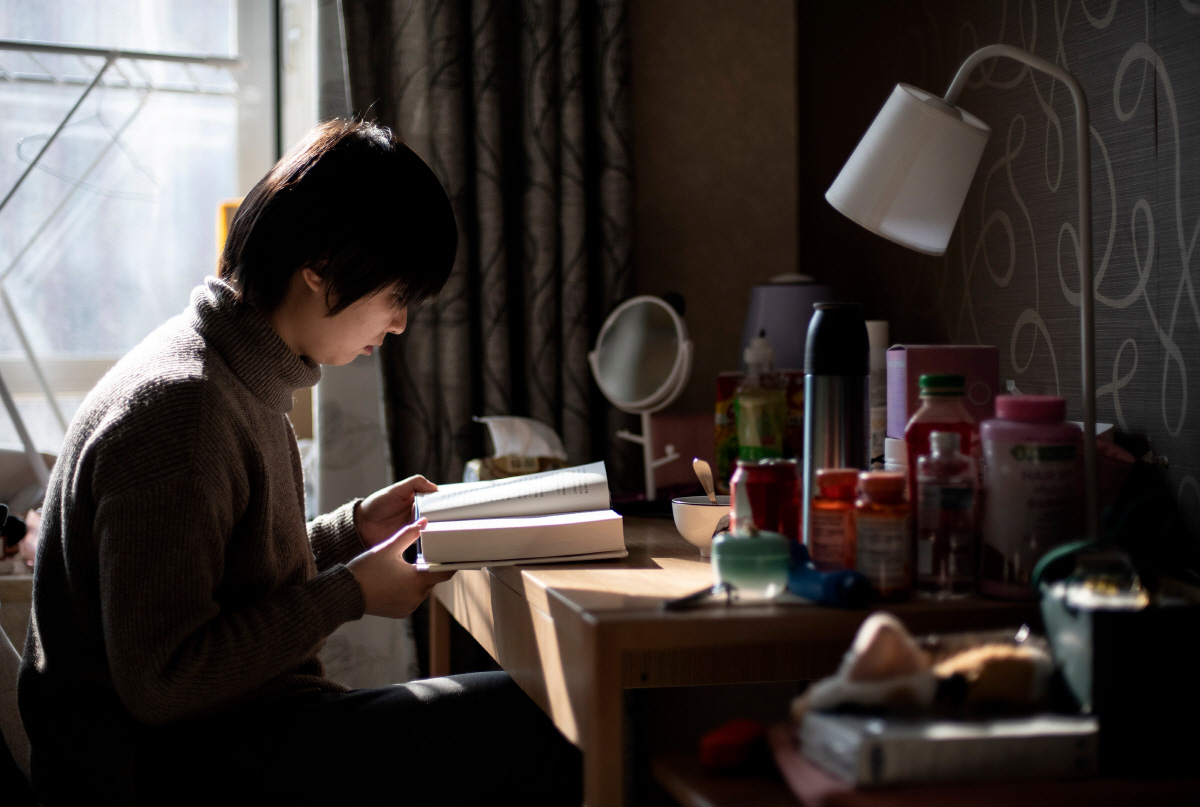 ▲신종 코로나바이러스 진원지인 중국 후베이성 우한 출신의 한 여성이 1월 31일(현지시간) 베이징의 자신의 집에서 격리된 채 책을 읽고 있다. 베이징/AFP연합뉴스