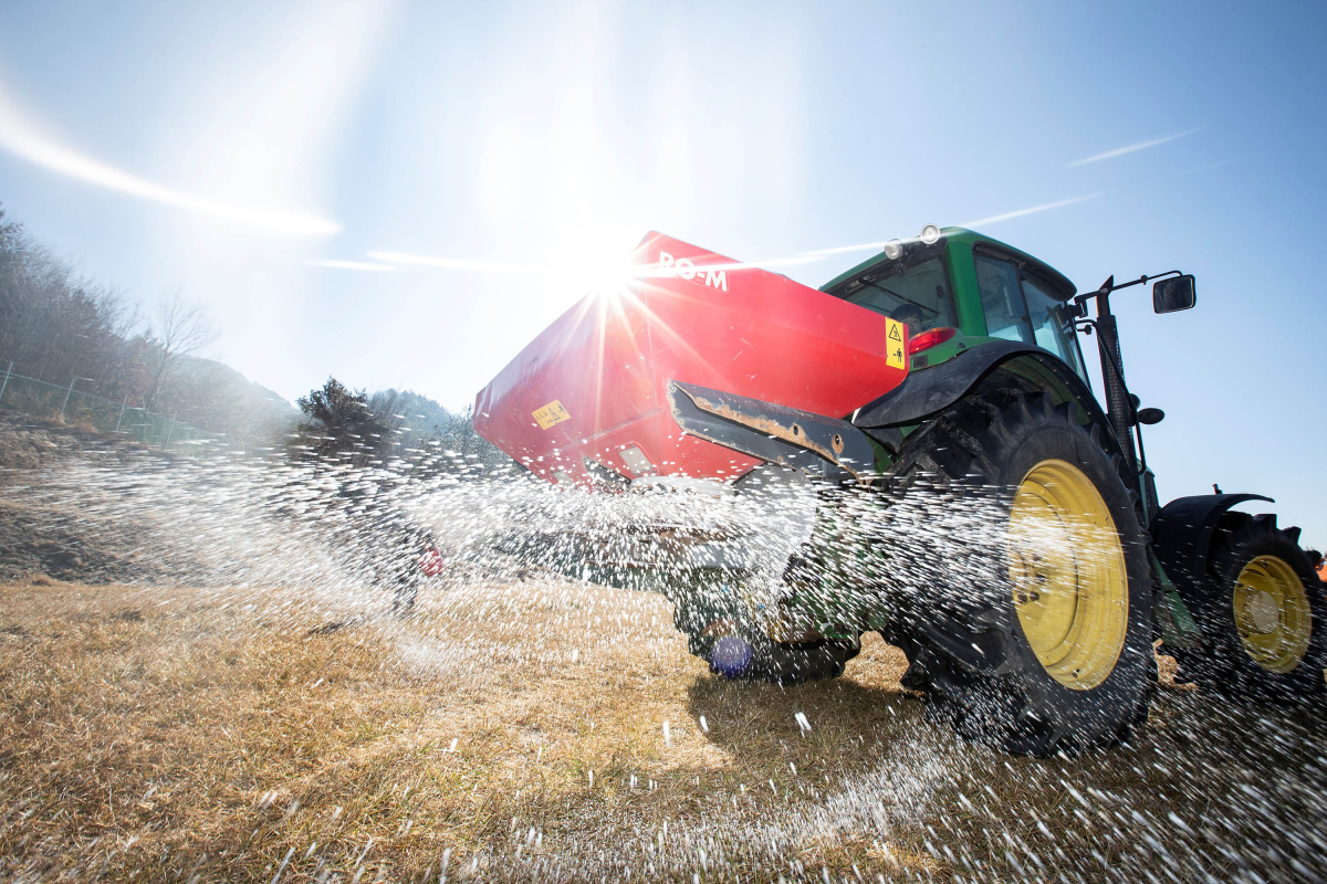 ▲ 농촌진흥청 직원들이 4일 경남 함양군 농촌진흥청 국립축산과학원 가축유전자원센터에서 초지에 비료를 주고 있다.  (사진제공=농촌진흥청)