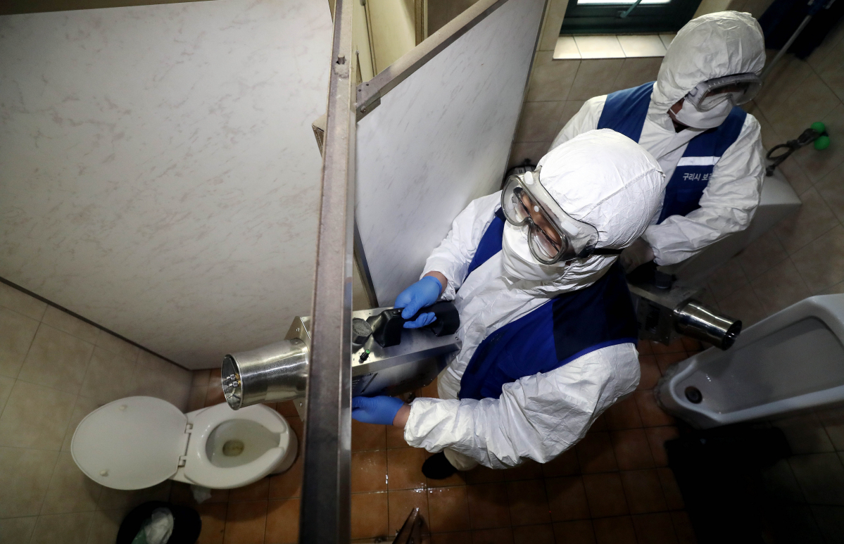 ▲구리시가 국내 17번째 신종 코로나 감염증 환자로 판정받은 38살 남성의 이동 경로라며 공개한 5일 오후 경기 구리의 상가 건물에서 구리시보건소 관계자들이 화장실 내부를 방역하고 있다. (뉴시스)