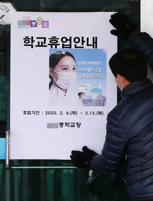 ▲신종코로나 확진자가 거주하거나 이동·체류한 곳과 인접한 서울 성북구의 한 중학교 출입문에서 학교 관계자가 교육청의 휴업 명령과 관련 안내문을 부착하고 있다. (연합뉴스)