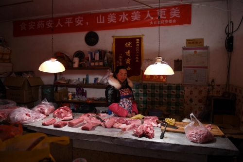 ▲중국 베이징에 있는 한 정육점에서 상인이 손님을 기다리고 있다. 베이징/AFP연합뉴스 
