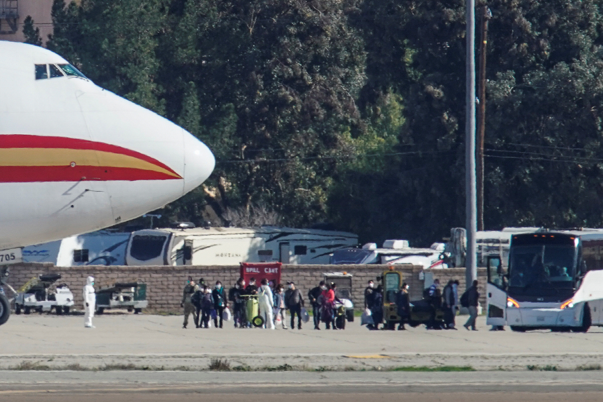 ▲중국 우한에 머물던 미국인들이 지난달 29일(현지시간) 미국 정부가 보낸 전세기편으로 캘리포니아 주 리버사이드 카운티의 마치 공군기지에 도착한 뒤 대기중인 버스에 탑승하고 있다.리버사이드 카운티/로이터연합뉴스
