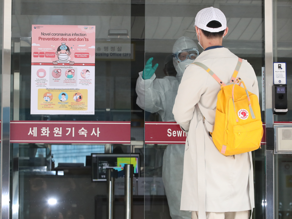 ▲24일 서울 동대문구 경희대학교에서 방학이 끝나 입국한 중국인 유학생이 방역복을 입은 관계자의 안내를 받고 있다. (연합뉴스)