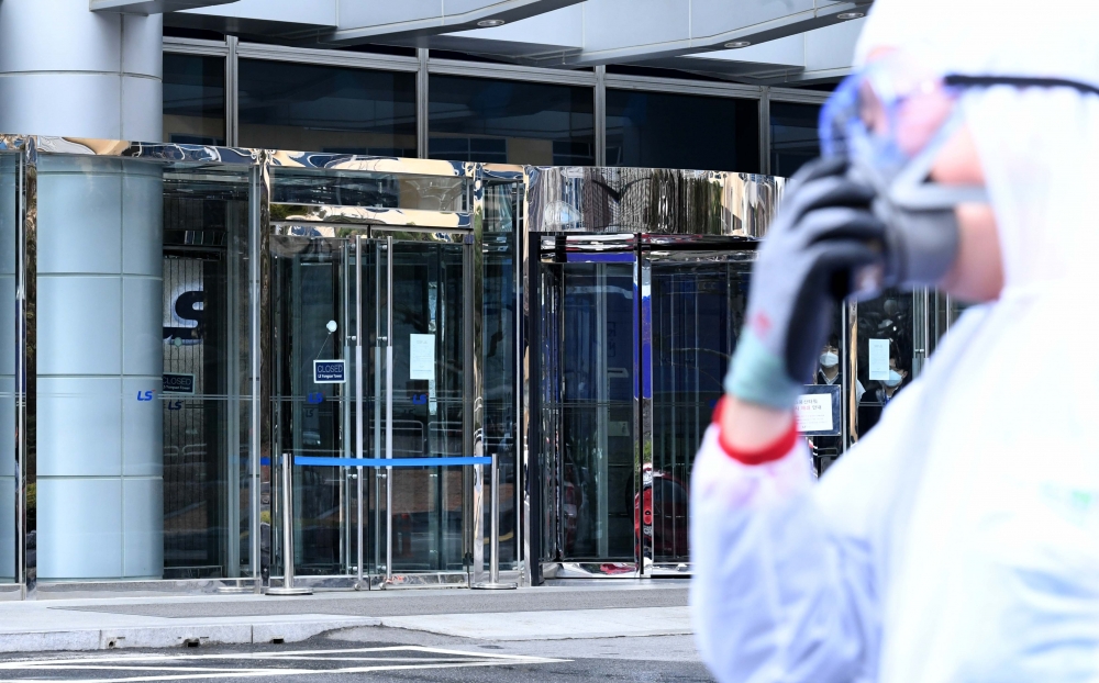 ▲25일 서울 용산구 LS용산타워가 신종 코로나바이러스 감염증(코로나19) 확진자 발생으로 임시 폐쇄된 가운데 방역업체 관계자들이 방역을 위해 건물로 들어서고 있다. LS그룹은 LS타워에 입주한 LS·LS니꼬동제련 등 계열사 임직원에게 26일까지 재택근무할 것을 명령했다. 신태현 기자 holjjak@ (이투데이DB)