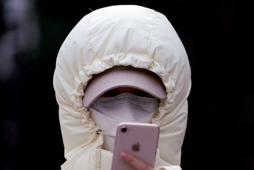 ▲중국 상하이에서 마스크로 얼굴을 가린 한 여성이 스마트폰을 들여다 보고 있다. 베이징/로이터연합뉴스 
