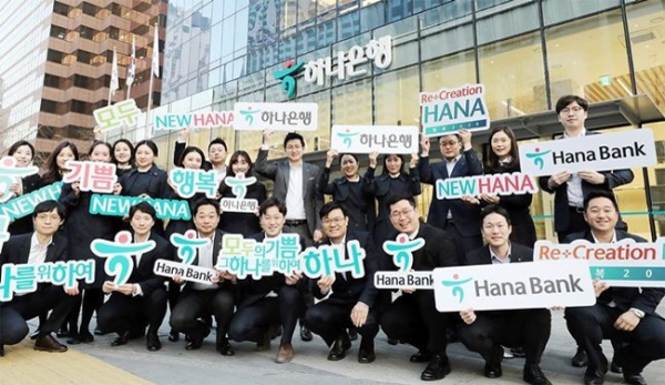 ▲하나은행 직원들이 서울 을지로 본점 앞에서 '하나은행'으로 새롭게 바뀐 브랜드를 소개하며 기념촬영을 하고 있다.(하나은행)