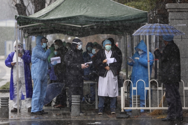 ▲중국 우한의 한 병원에서 15일(현지시간) 공무원들이 방호복을 입고 마스크를 쓴 채 코로나19 환자가 도착하는 것을 기다리고 있다. 우한/AP뉴시스 
