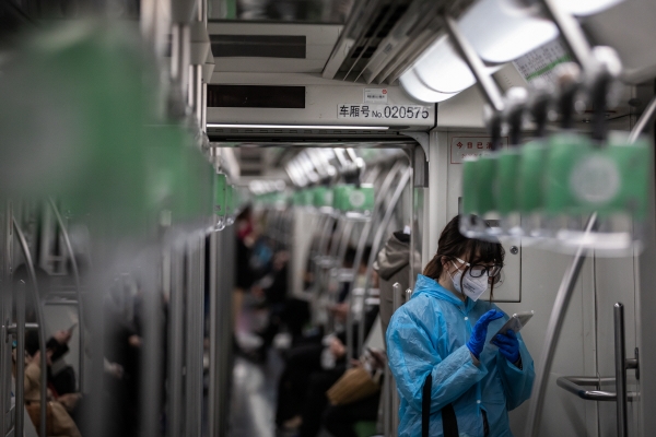 ▲24일(현지시간) 마스크와 장갑, 우비를 착용한 여성이 중국 상하이 지하철에서 휴대전화를 사용하고 있다. 상하이/EPA연합뉴스
