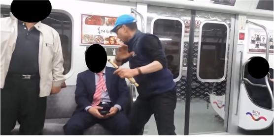 ▲7호선 열차 내에서 술에 취한 노인이 다른 승객을 위협하고 있다.   (사진 = 서울시)