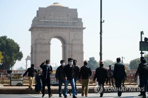▲마스크를 쓰고 인도 뉴델리 시내 인디아게이트 앞을 지나는 관광객. (AFP=연합뉴스)