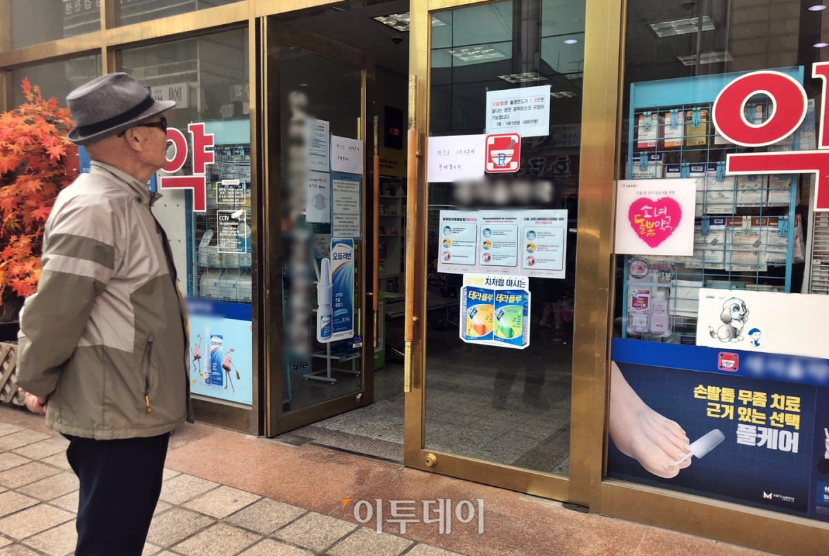 ▲서울 강서구에서 한 시민이 약국 정문에 붙어 있는 공고문을 읽고 있다. 그는 여러 번 읽고도 "어렵다"라고 기자에게 말했다. (홍인석 기자 mystic@)