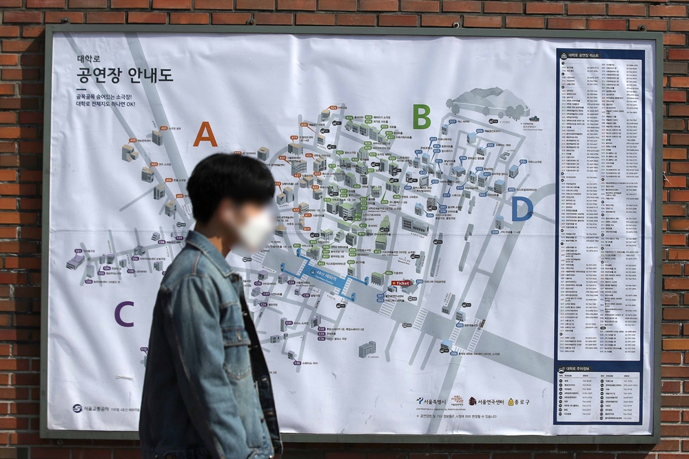 ▲8일 연극 공연장이 다수 위치한 서울 종로구 대학로에서  코로나19 감염을 방지하기  위해 마스크를 쓴 시민이 공연장 안내도 앞을 지나고 있다. (뉴시스)