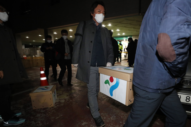 ▲17일 오후 서울 강서구 화곡동 신천지예수교증거장막성전 바돌로메 지파 본부에서 종합행정조사를 마친 서울시 관계자들이 확보한 자료를 들고 시설을 나서고 있다. (연합뉴스)