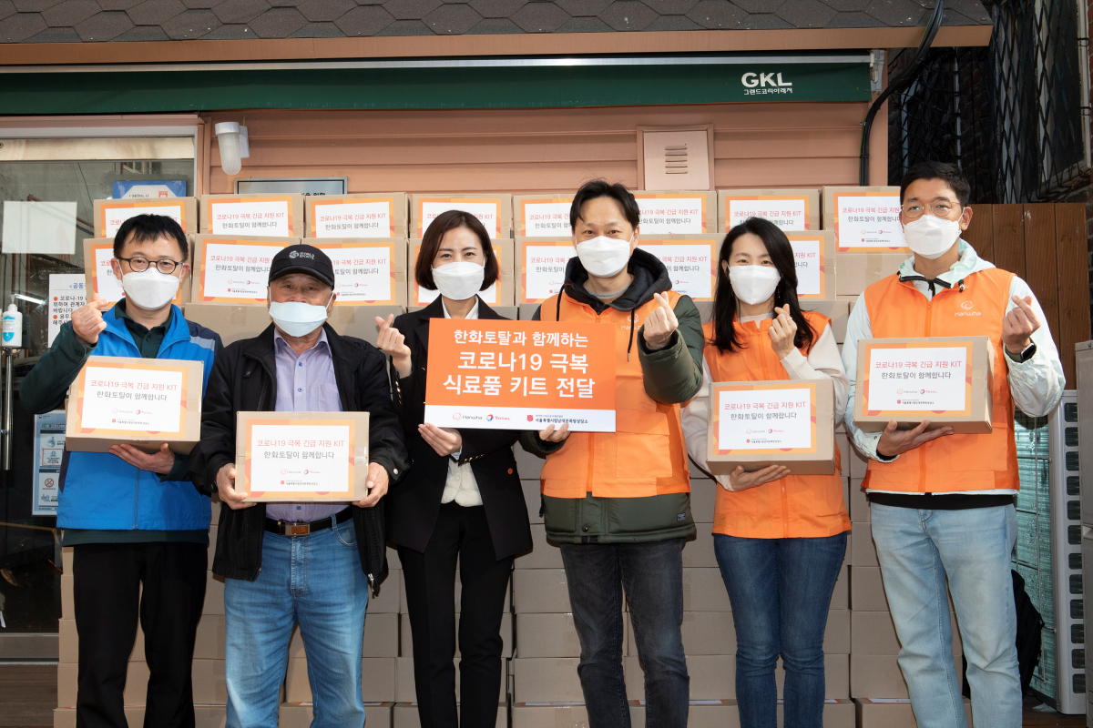 ▲전지환(오른쪽 세번 째) 한화토탈 커뮤니케이션팀장과 정수현(오른쪽 네 번째) 서울특별시립남대문쪽방상담소 소장이 24일 남대문 쪽방촌에서 열린 '코로나19 극복 식료품 키트 전달식'에서 기념사진을 찍고 있다. (사진제공=한화토탈)