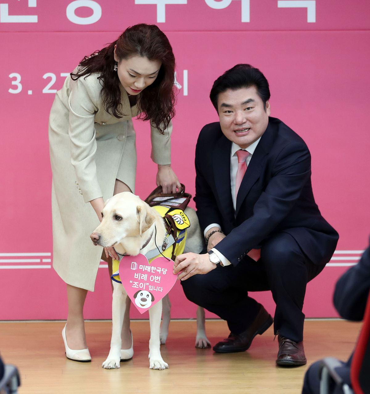 ▲미래한국당 원유철 대표(오른쪽)가 27일 오후 서울 영등포구 여의도 미래한국당 당사에서 열린 비례대표 후보 공천장 수여식에서 시각장애 피아니스트 김예지 후보의 안내견인 '조이'에게 비례대표 0번 목걸이를 걸어주고 있다. (연합뉴스)