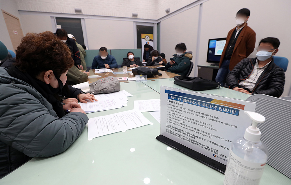 ▲신종 코로나바이러스 감염증(코로나19)으로 피해를 입은 소상공인에 대한 경영안정자금 직접대출 접수가 시행 중인 26일 오전 서울 종로구 소상공인시장진흥공단 서울중부센터에서 소상공인들이 관련 서류를 작성하고 있다. (뉴시스)