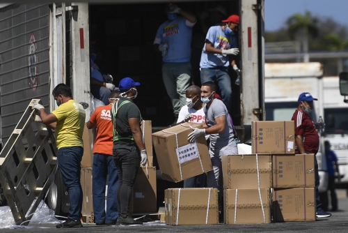 ▲마스크 등 중국산 의료 물품이 베네수엘라 과이라의 국제공항에 28일(현지시간) 도착한 가운데 근로자들이 하역 작업을 하고 있다. 과이라/AP연합뉴스 
