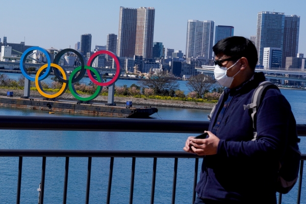 ▲한 관광객이 일본 도쿄의 올림픽 링 부근에서 마스크를 쓴 채 주위를 둘러보고 있다. 도쿄/EPA연합뉴스
