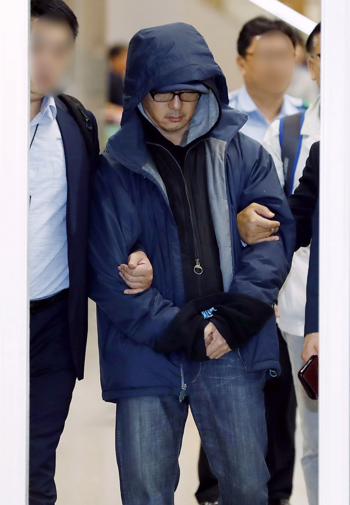 ▲도피 생활 중 해외에서 붙잡힌 한보그룹 정태수 회장의 넷째 아들 정한근 씨가 22일 인천국제공항을 통해 송환되고 있다.  (뉴시스)