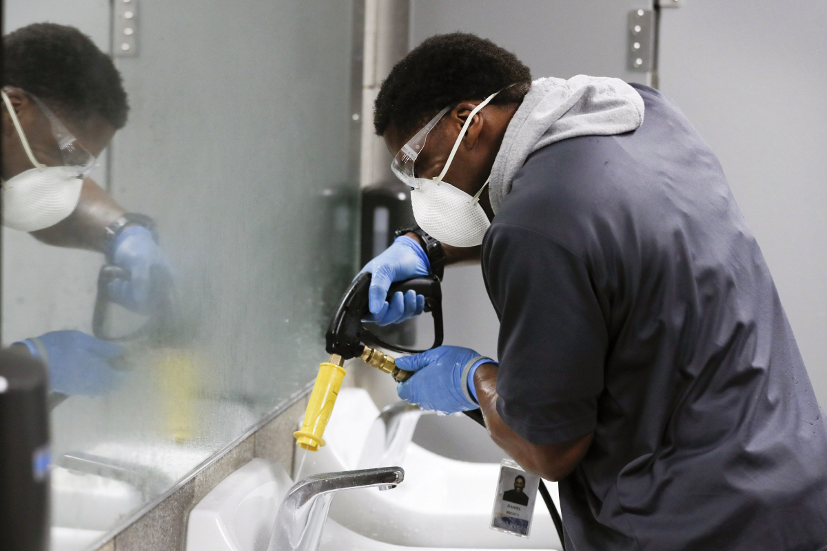 ▲미국 아이오와주 데스모인의 한 공립 고등학교에서 직원이 미스크를 쓰고 화장실을 소독하고 있다. 데스모인/AP뉴시스