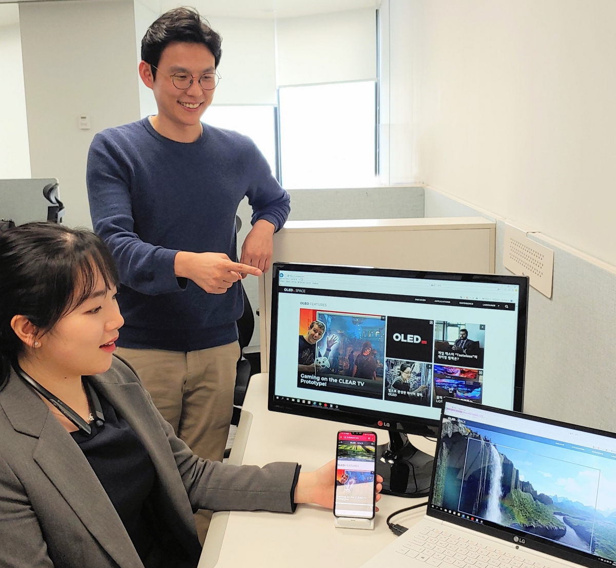 ▲ LG디스플레이 직원들이 개편된 올레드 스페이스 화면을 보고 있다. (사진제공=LG디스플레이)
