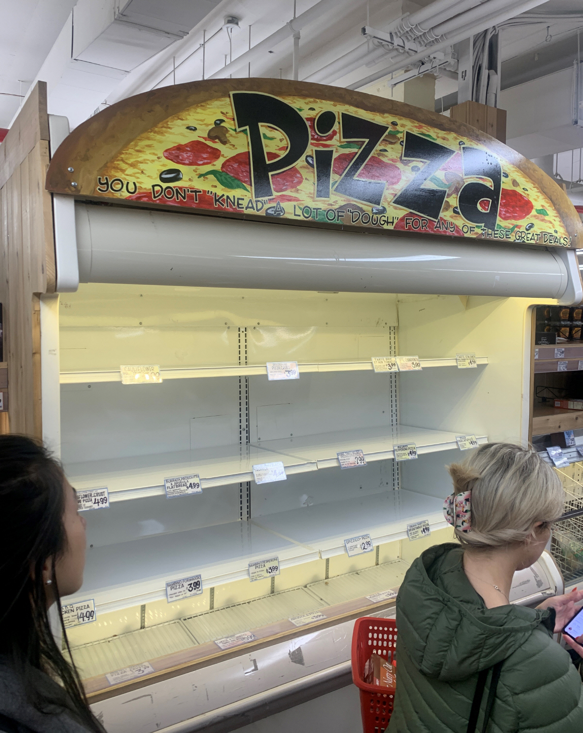 ▲3월 12일(현지시간) 미국 뉴욕의 한 마켓에서 소비자들이 빈 냉동피자 진열대 앞을 지나가고 있다. 뉴욕/AP연합뉴스.
