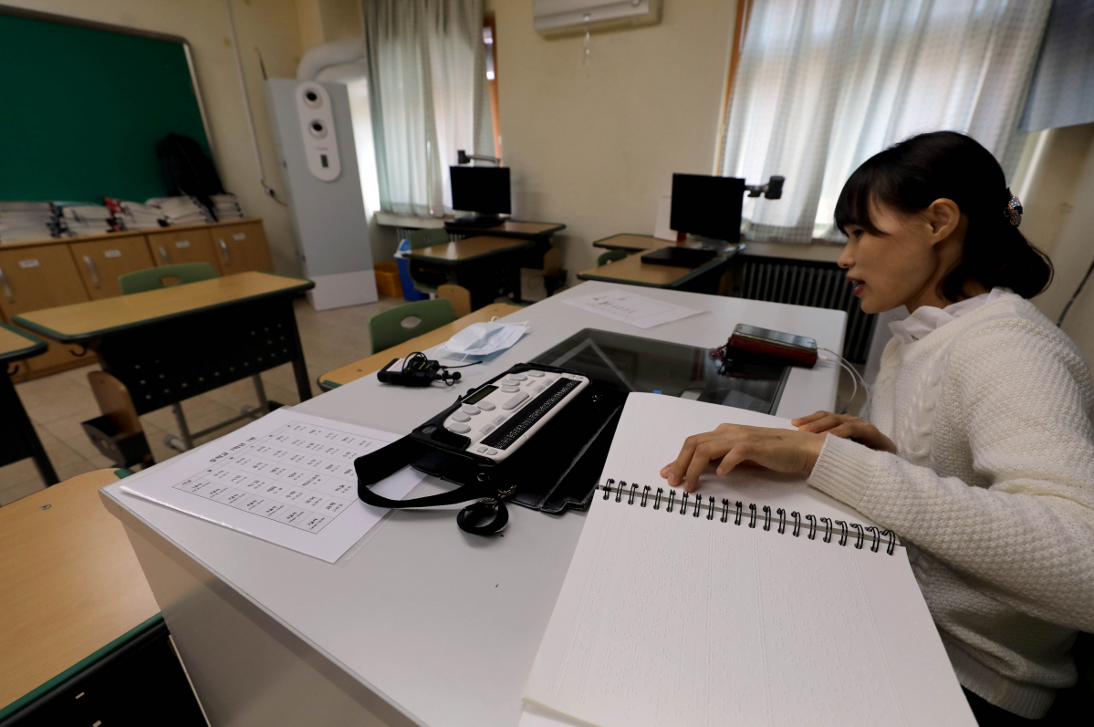 ▲8일 서울 종로에 위치한 시각장애 특수학교인 서울맹학교에서 신종 코로나바이러스 감염증(코로나19)로 인한 원격수업이 진행되고 있는 가운데 국어과 김현아 교사가 점자정보단말기와 점자책을 이용해 학생들과 수업을 진행하고 있다.  (연합뉴스)