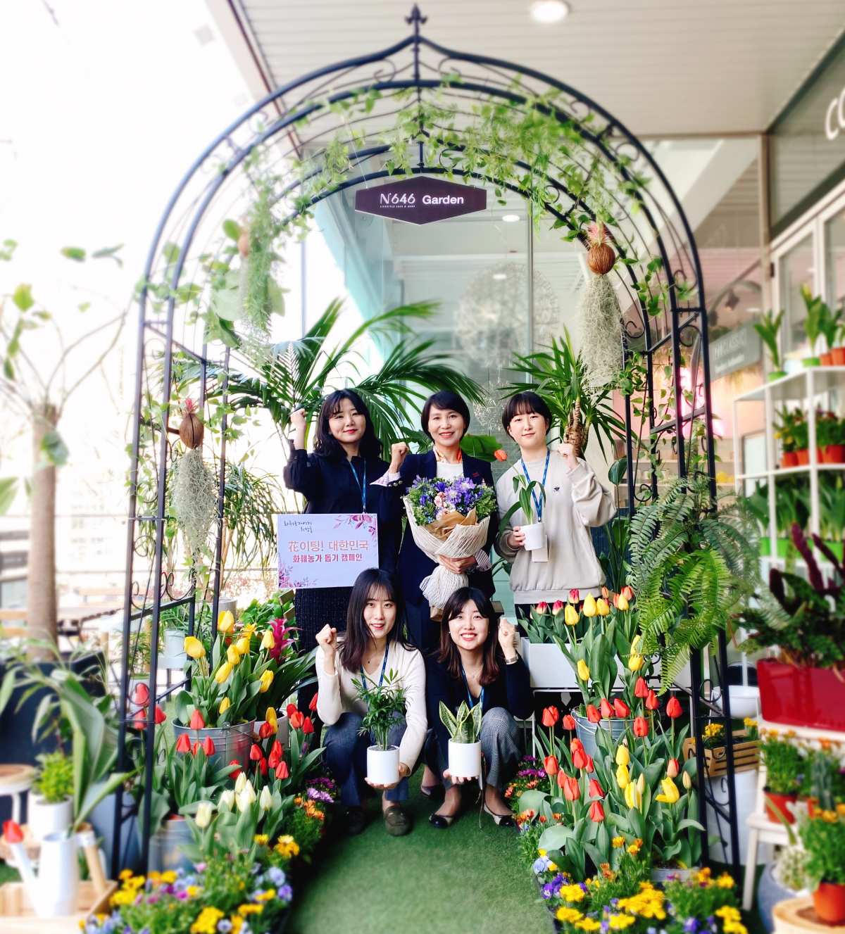 ▲박미경 한국여성벤처협회장(가운데)이 자사인 포시에스 내부에 조성한 튤립 가든에서 직원들과 기념촬영을 하고 있다. (사진제공=여성벤처협회)