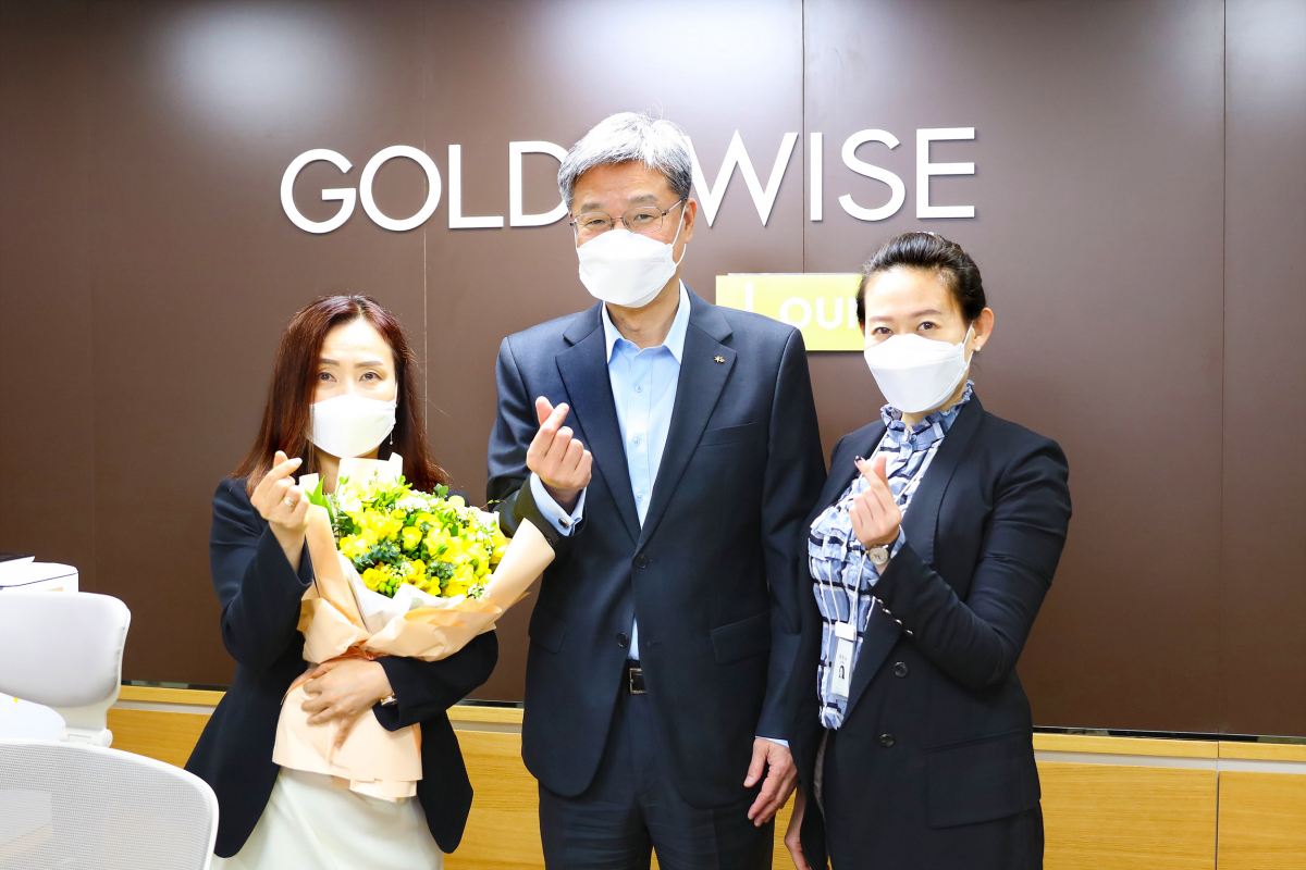 ▲허인 KB국민은행장(가운데)이 8일 서울 여의도영업점을 찾아 직원들에게 프리지아 꽃을 선물하고, 기념촬영을 하고 있다. (사진제공=KB국민은행)