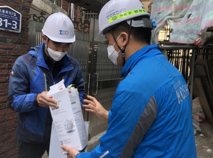 ▲한국산업안전보건공단 직원(오른쪽)이 건설현장 근로자에게 마스크를 전달하고 있는 모습.(사진:한국산업안전보건공단)
